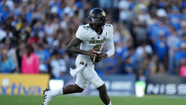 Colorado Buffaloes quarterback Shedeur Sanders runs with the football.